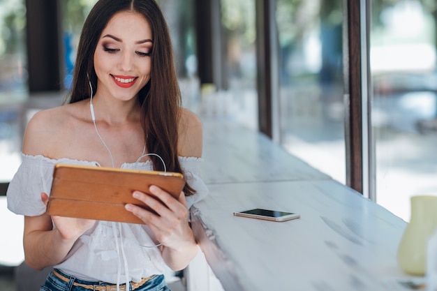 Chica joven sonriendo con una tablet