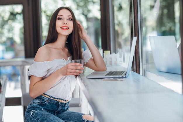 Chica jóven sonriendo con un vaso en la mano