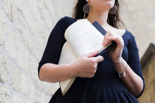 Foto gratuita chica joven sujetando un libro