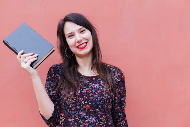 Foto gratuita chica joven sujetando un libro