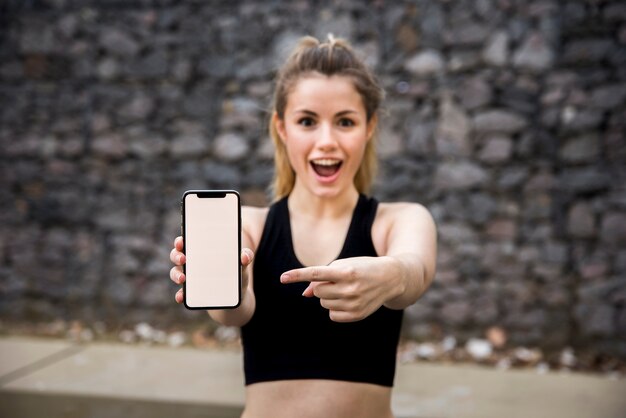 Chica joven sujetando un teléfono móvil