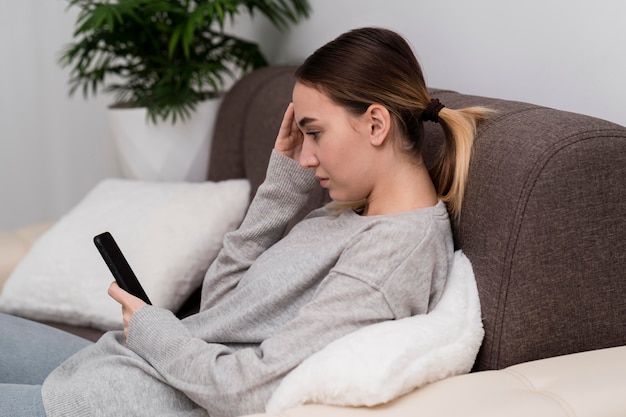 Foto gratuita chica joven con teléfono en casa