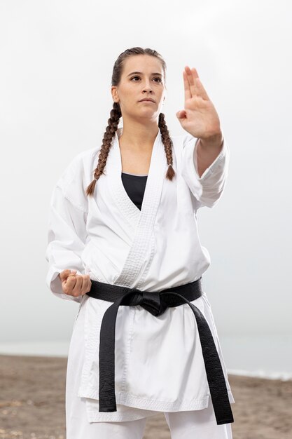 Chica joven en traje de karate al aire libre