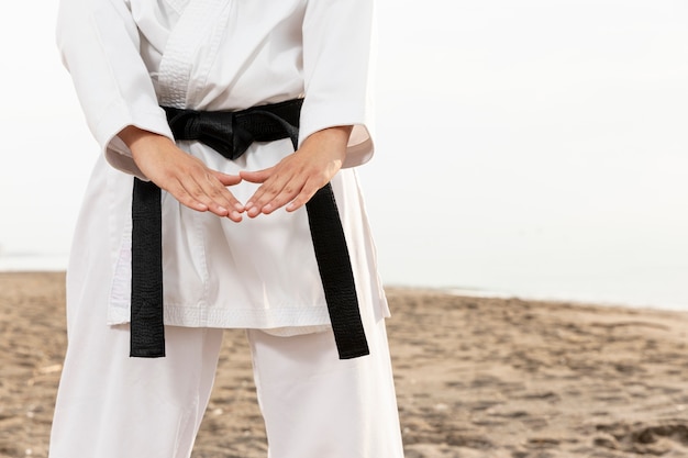 Chica joven en traje de karate al aire libre