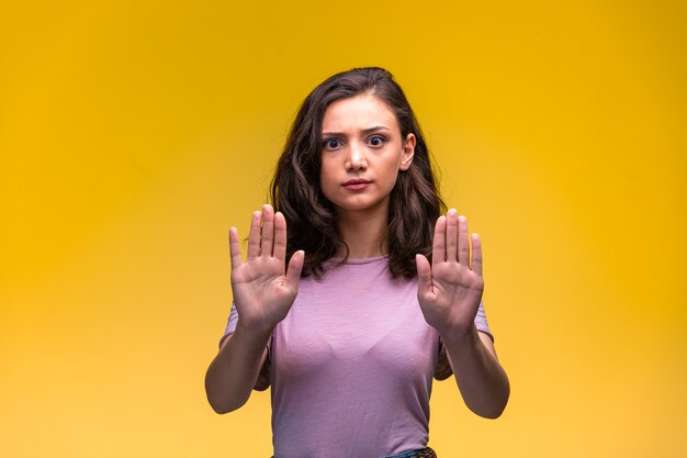 Chica joven tratando de prevenir el peligro por delante.