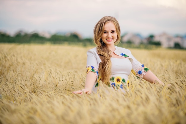 Chica joven en vestido nacional ucraniano posó en el campo de la corona