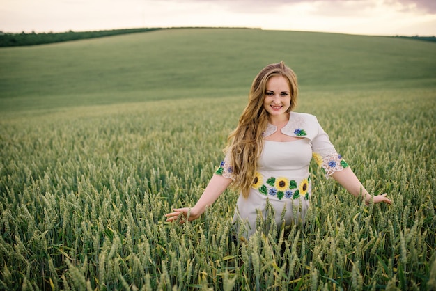 Chica joven en vestido nacional ucraniano posó en el campo de la corona