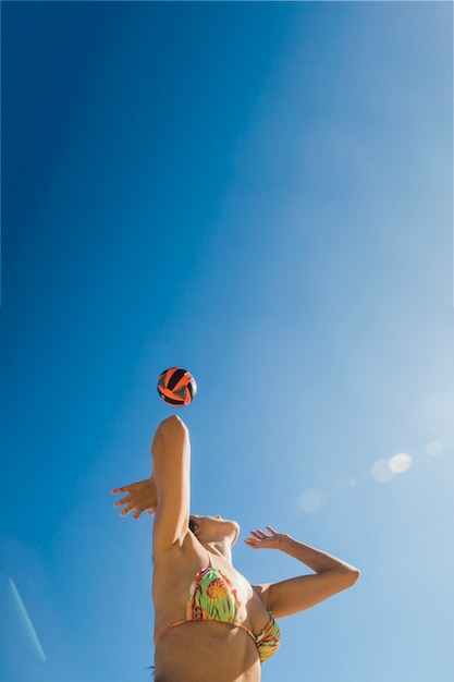 Chica jugando al voleibol en un día soleado