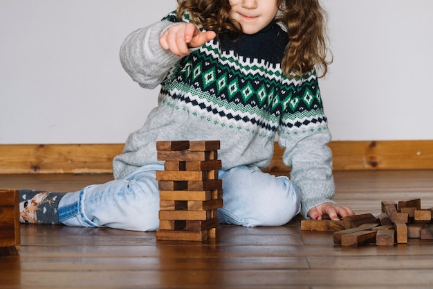 Chica jugando jenga en casa