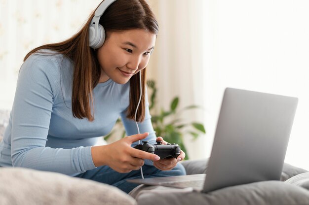 Chica jugando videojuegos en portátil