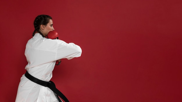 Foto gratuita chica de karate de artes marciales con cinturón negro y copia espacio de fondo