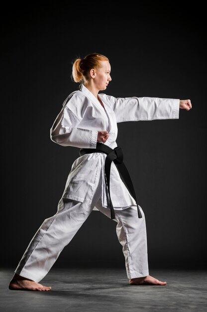 Chica de karate practicando vista lateral