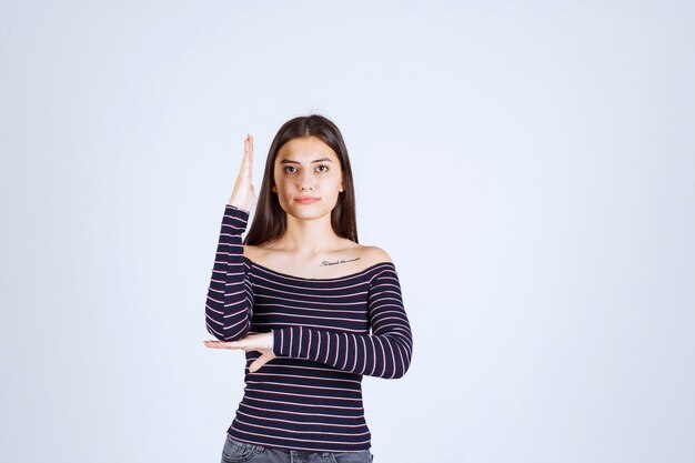 Chica levantando la mano para llamar la atención.