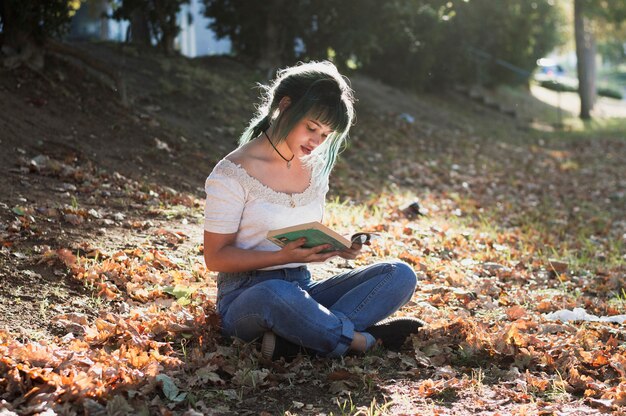 Chica leyendo en colina soleada