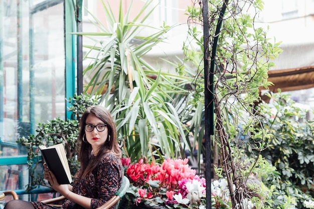 Chica leyendo un libro en una cafetería