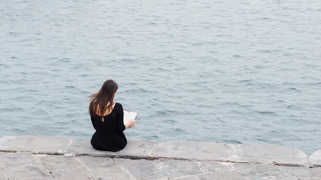 Chica leyendo un libro en la calle