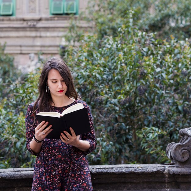 Chica leyendo un libro en la calle