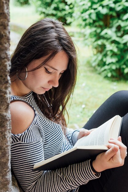 Chica leyendo un libro en la calle