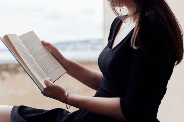 Chica leyendo un libro en la calle