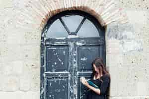 Foto gratuita chica leyendo un libro en la calle