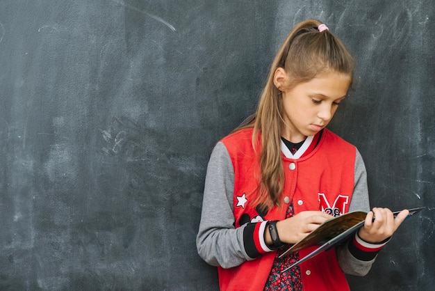 Foto gratuita chica libro de lectura en el aula