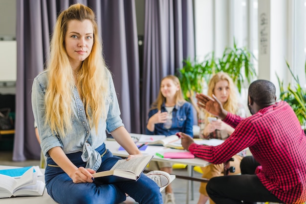 Foto gratuita chica con libro sobre la mesa