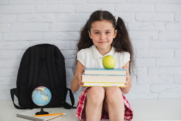 Foto gratuita chica con libros y manzanas