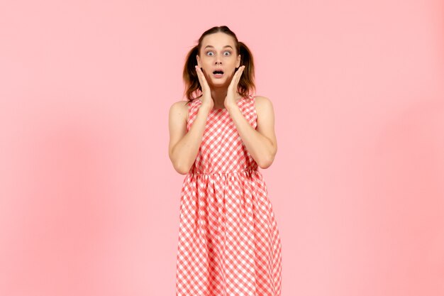 chica con lindo vestido brillante con expresión de sorpresa en rosa