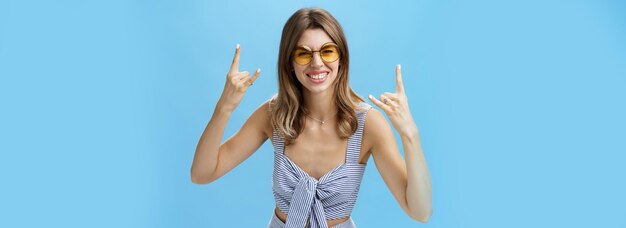 Chica lista para rock'n'roll esta fiesta con el mejor traje de juego del armario y gafas de sol geniales