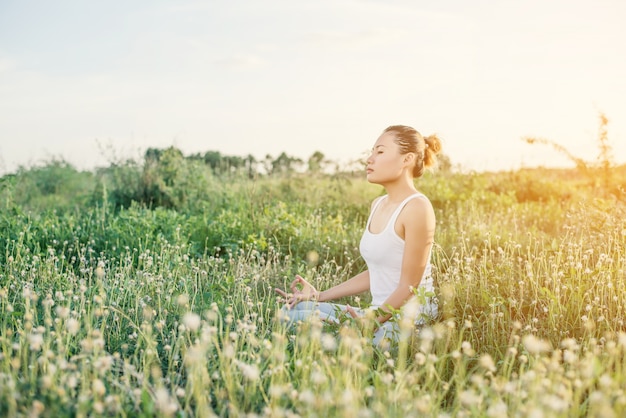 Chica meditando al atardecer