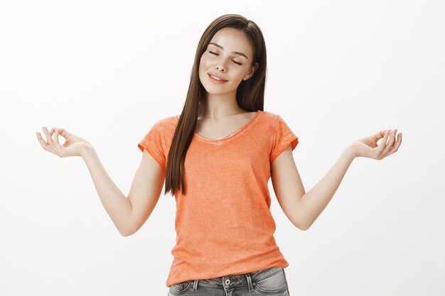 Chica meditando pacífica, hermosa mujer practica yoga, sensación de calma, libera el estrés