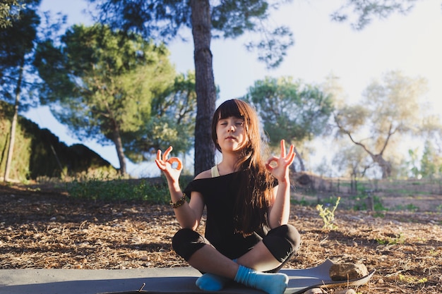 Chica meditando en el parque