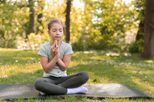 Chica meditando sobre estera de yoga