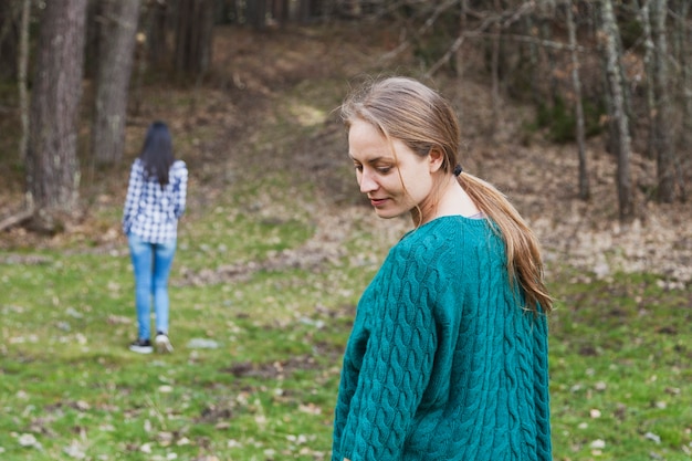 Foto gratuita chica mirando hacia atrás con su amiga de fondo