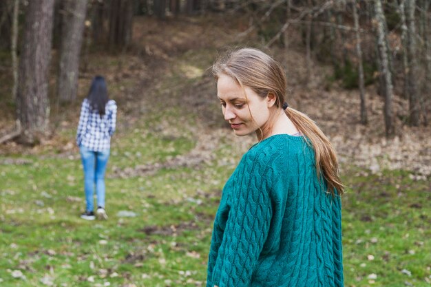 Chica mirando hacia atrás con su amiga de fondo