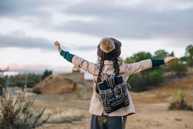 Chica con mochila en la naturaleza