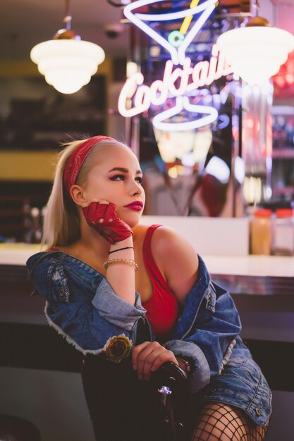 Chica de moda en un café vintage en el estilo de pin-up.