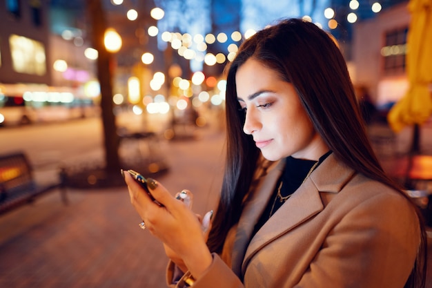 Chica de moda caminando en una ciudad de noche