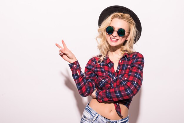 Chica de moda mujer en gafas de sol negras y sombrero negro aislado en rosa