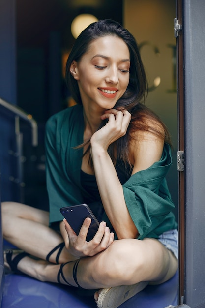 Chica de moda de pie en un café de verano