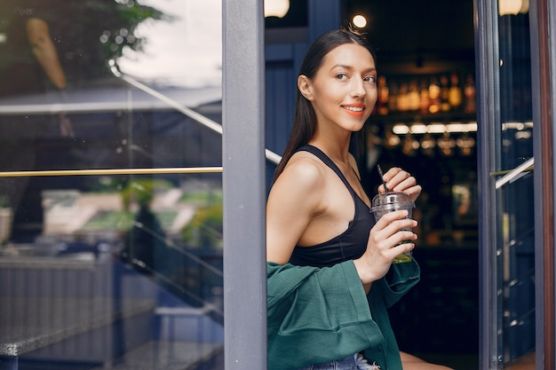 Chica de moda de pie en un café de verano