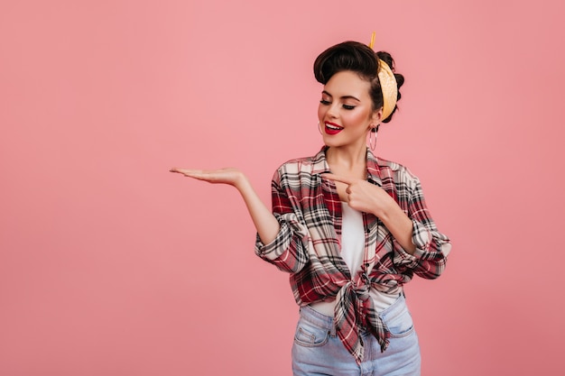 Foto gratuita chica modela agradable posando con la mano hacia arriba. disparo de estudio de linda mujer joven en traje vintage.