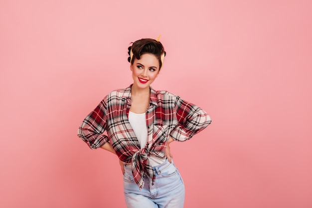 Foto gratuita chica modela romántica posando con los brazos en jarras. disparo de estudio de mujer joven elegante en camisa a cuadros.