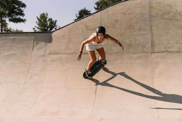 Foto gratuita chica moderna con casco skating en medio tubo