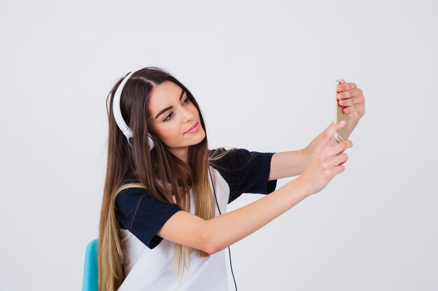 Chica moderna haciéndose un selfie