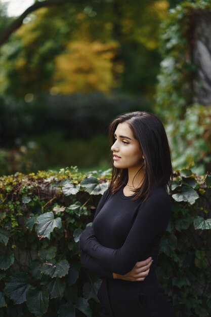 chica morena caminando por el parque durante el otoño