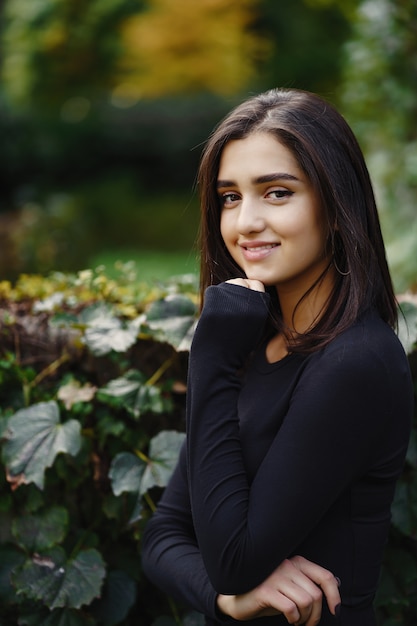 chica morena caminando por el parque durante el otoño