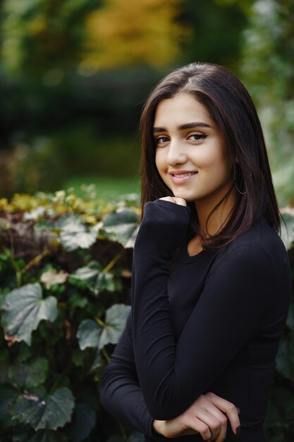 chica morena caminando por el parque durante el otoño