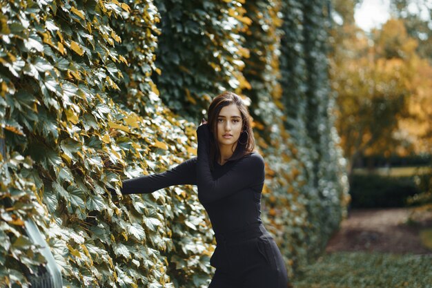 Chica morena caminando por el parque durante el otoño