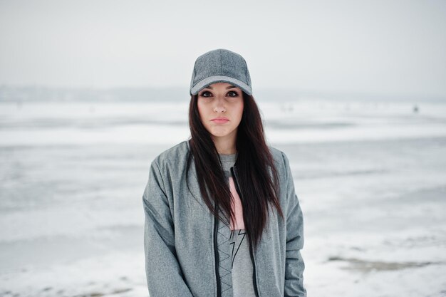 Chica morena con estilo en gorra gris estilo casual street en día de invierno